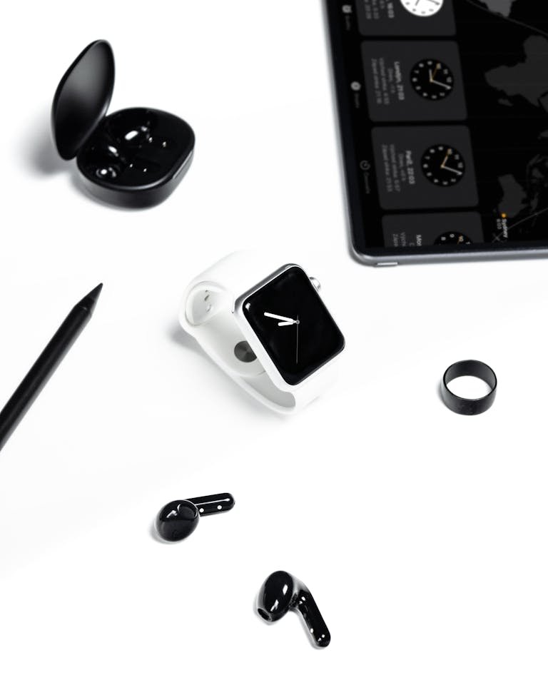 Stylish display of a modern workspace with gadgets like smartwatch, tablet, and headphones in a minimalist setting.
