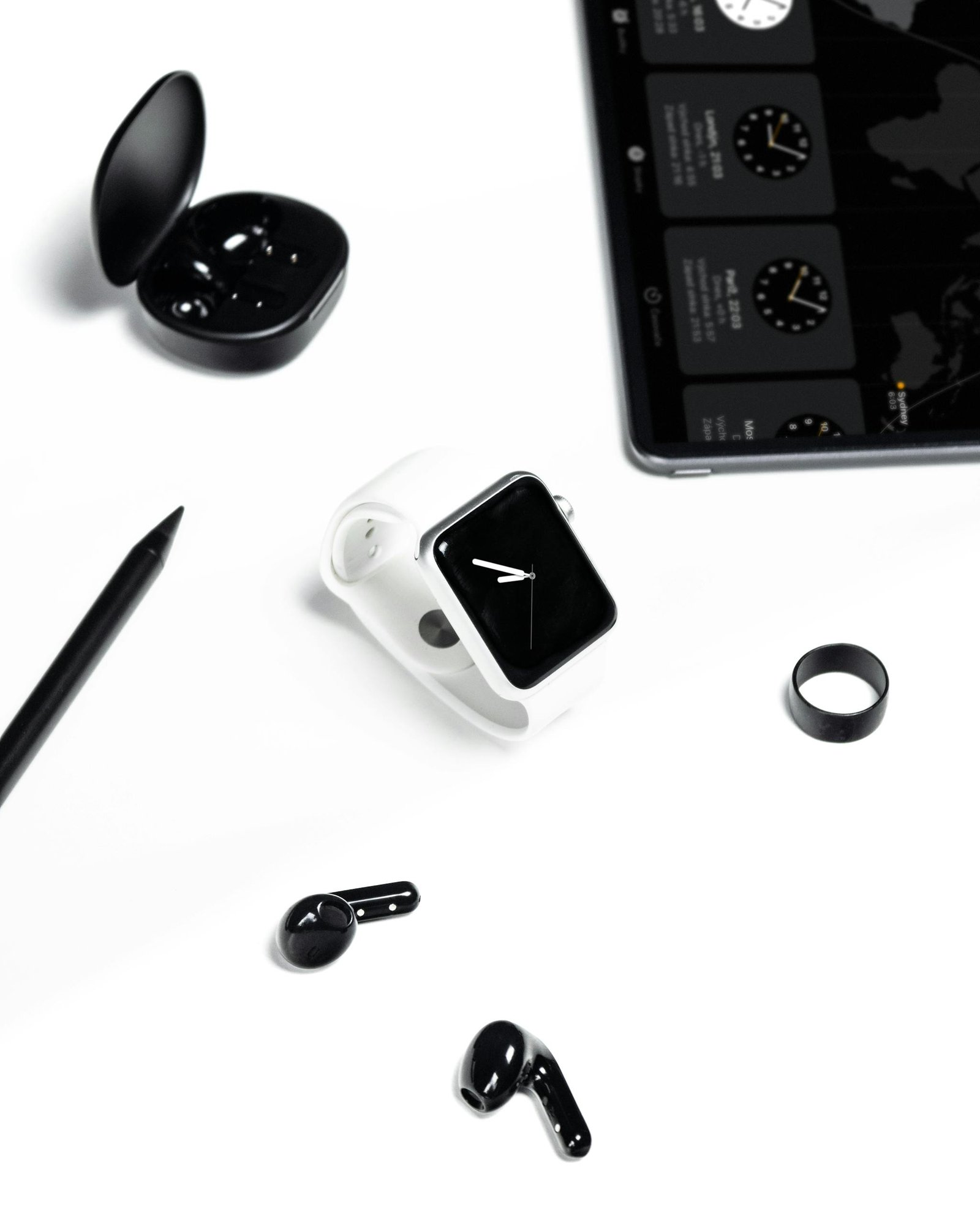 Stylish display of a modern workspace with gadgets like smartwatch, tablet, and headphones in a minimalist setting.